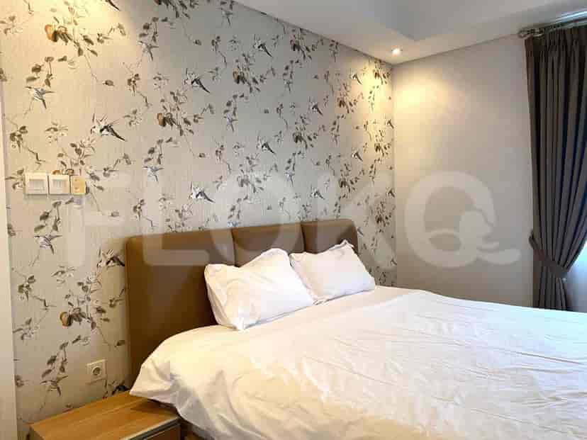 A bedroom with a double bed, patterned wallpaper, and a neutral color palette.
