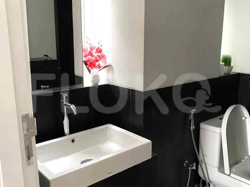 A minimalist bathroom with a white sink, black accents, and a large mirror.