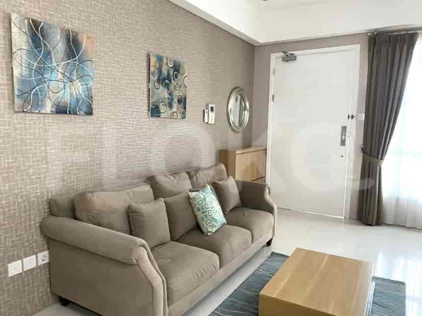 A cozy living room with a grey sofa, art, and a wooden coffee table.