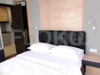 Kamar tidur yang menampilkan tempat tidur, meja samping tempat tidur, dan pintu.