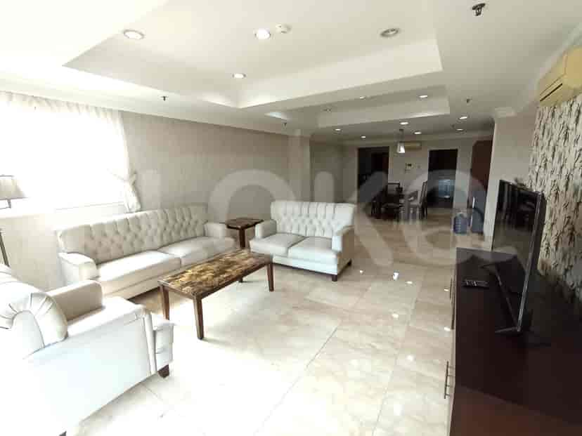 Spacious living room with multiple white sofas, coffee table, and entertainment system.