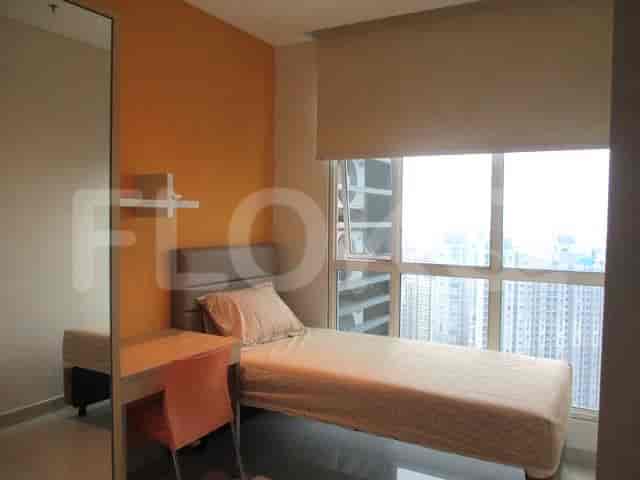 Kamar tidur kedua yang menampilkan tempat tidur single dan meja.