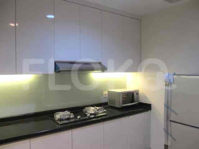 Dapur kontemporer dengan lemari putih, microwave, dan kompor listrik.