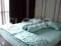 Kamar tidur yang menampilkan tempat tidur dengan seprai biru muda dan headboard empuk.