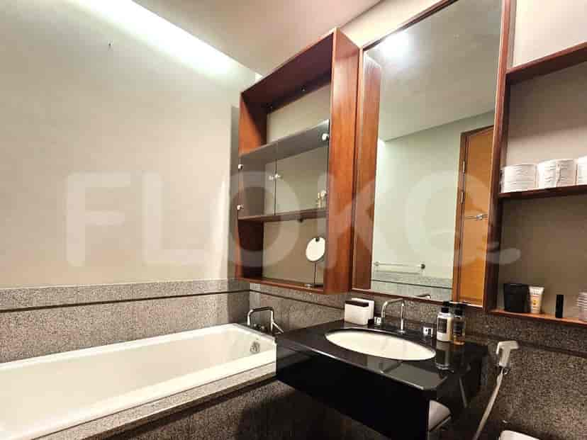 Kamar mandi dengan bathtub, meja rias, dan lemari kayu.