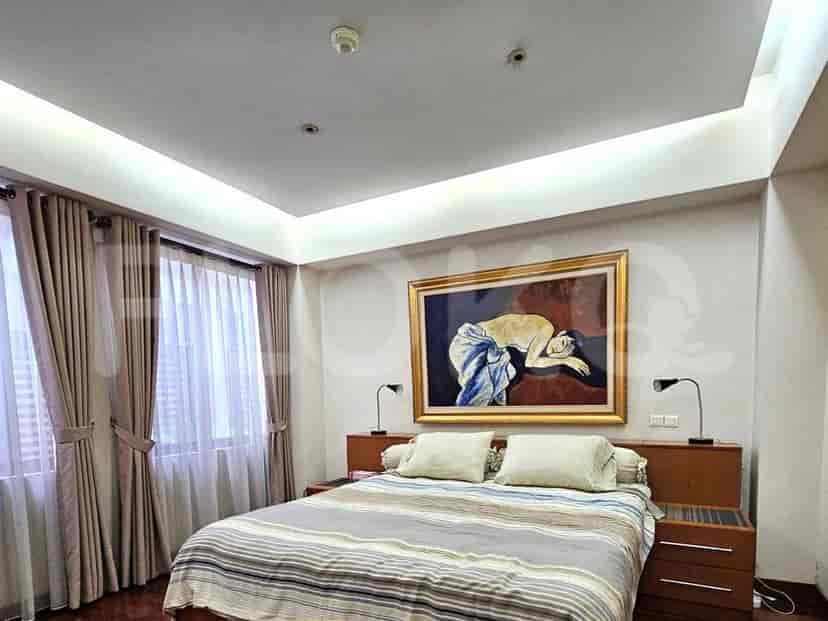 Kamar tidur dengan tempat tidur, karya seni, dan pencahayaan tersembunyi.