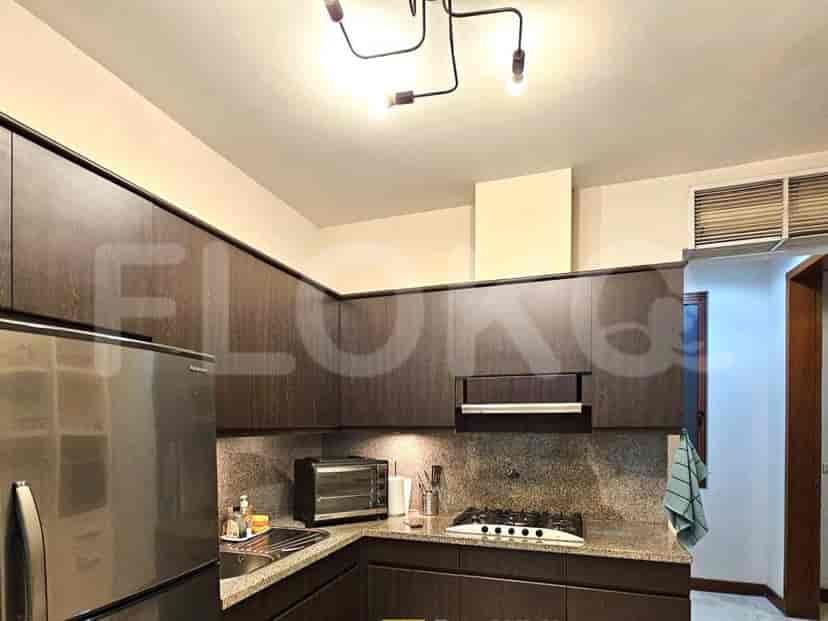 Dapur modern dengan lemari kayu gelap dan peralatan stainless steel.