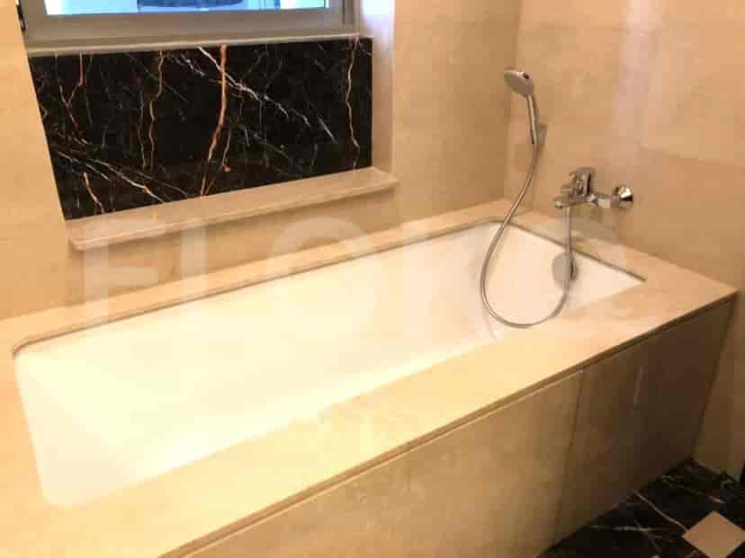 Kamar mandi mewah dengan bak mandi built-in, aksen marmer, dan pancuran genggam.