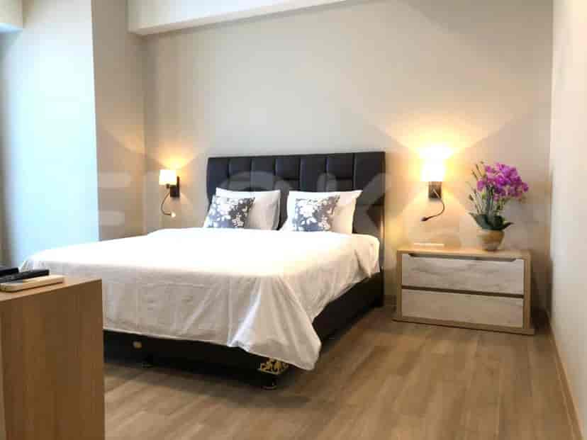 Kamar tidur modern yang menampilkan tempat tidur ukuran queen, lampu samping tempat tidur, dan lantai kayu.
