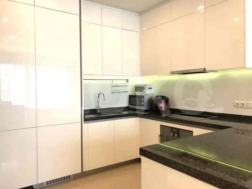 A modern kitchen with white cabinets and black countertops.