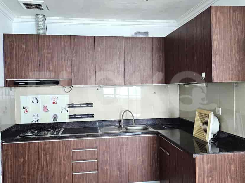 A modern kitchen with wooden cabinets and dark countertops.