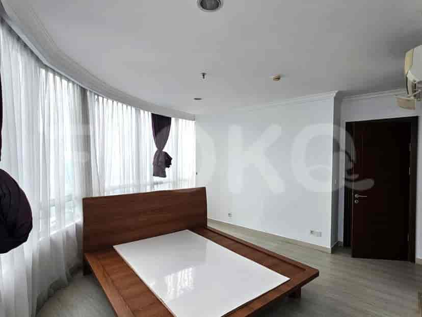 Bedroom with a wooden bed frame and curtains.