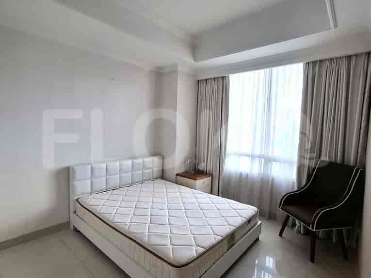 A bedroom with a bed, chair, and window.