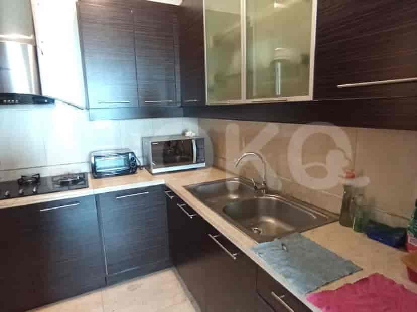 A kitchen with cabinets, a stove, a microwave, and a sink.