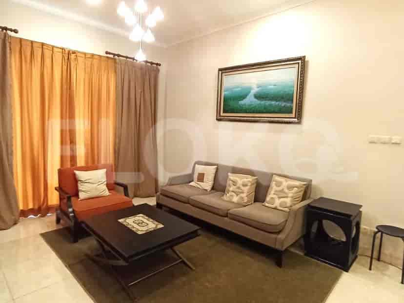 A living room with a sofa, arm chair, coffee table, and a painting on the wall.