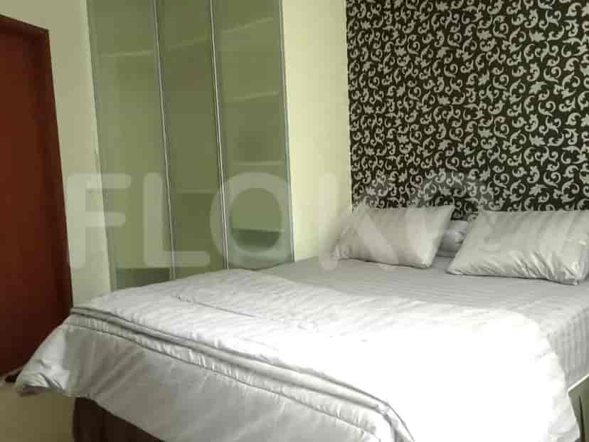 A bedroom with a bed, wardrobe, and patterned accent wall.