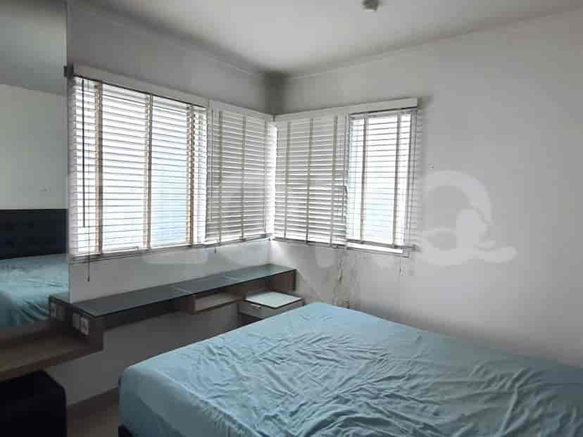 Bedroom with bed, windows, and desk area.