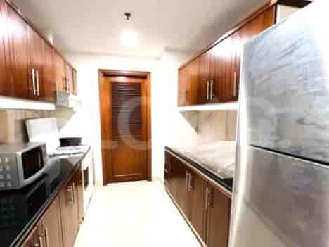 A closed kitchen with wooden cabinets and modern appliances.