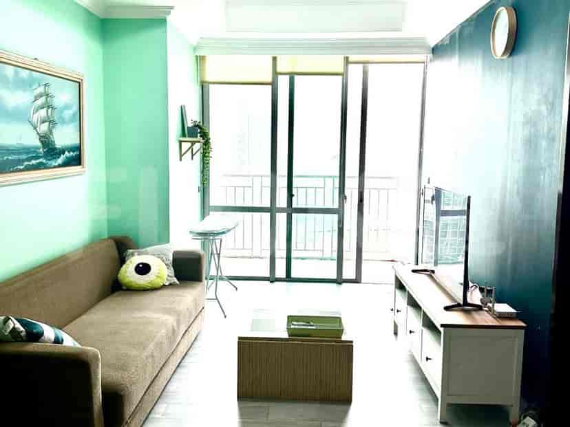 Living room with sofa, TV, and a view.