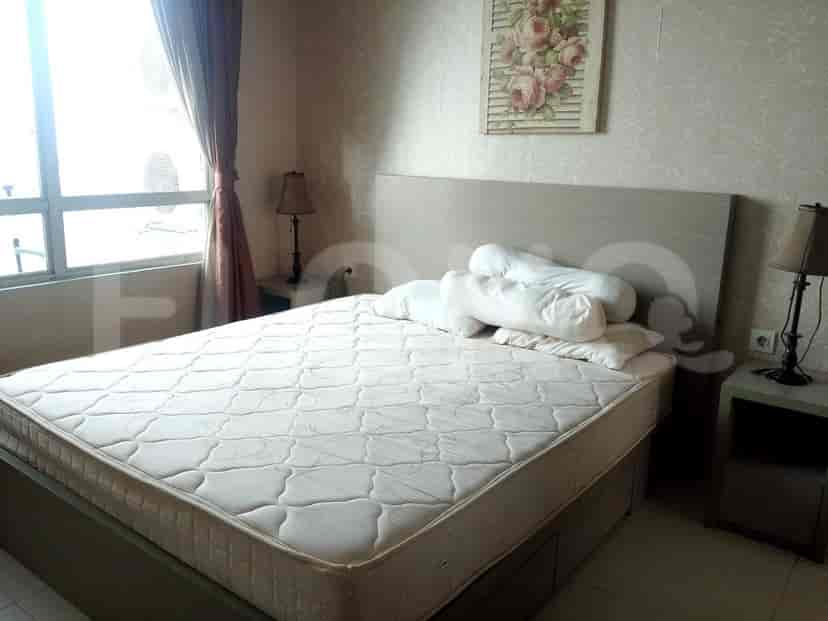 A bright bedroom with a large bed, bedside tables and a painting.