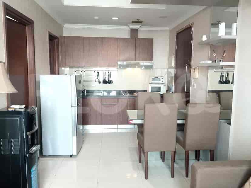 A modern kitchen featuring wood cabinets, appliances, and a dining area.