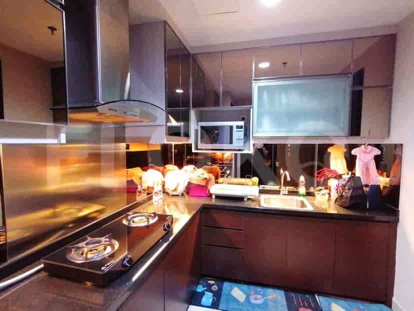 A modern kitchen with a gas stove, stainless steel backsplash, and microwave.