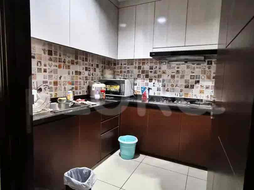 Modern kitchen with wooden cabinets and mosaic tiles.