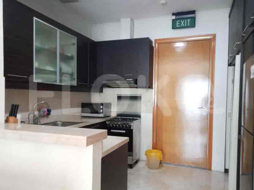 Dapur dengan microwave, kompor gas, dan lemari kayu.