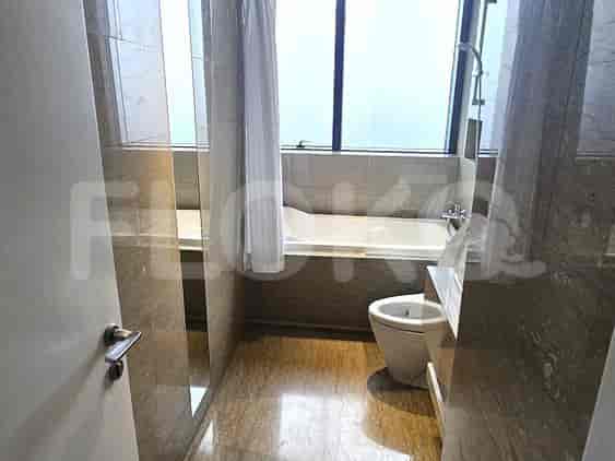 Bathroom with a bathtub, toilet, and tiled walls.
