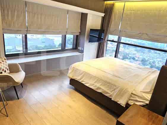 Bedroom with a bed near the window, hardwood flooring, and views of the city.