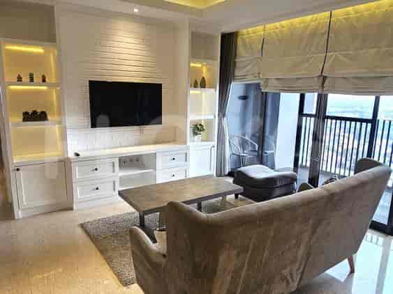 Modern living room with a grey sofa, a brick wall, and a large window overlooking the city.