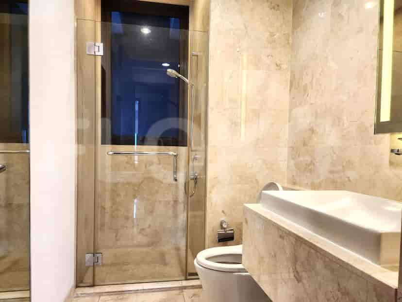 A modern bathroom with a walk-in shower and marble finishes.