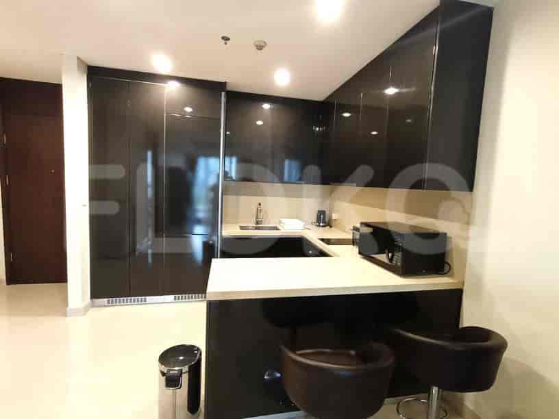 A sleek kitchen with dark cabinets, a breakfast bar, and modern appliances.