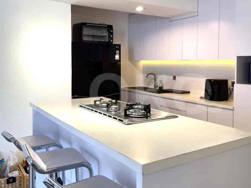 A modern kitchen with white cabinets, a stovetop, and an island.