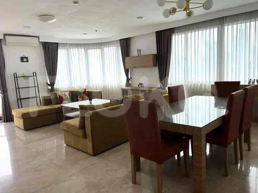 Living room with curved windows, yellow sofa, and dining area.