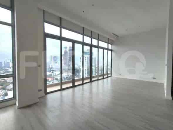 Spacious living room with large windows, city views, and light wooden flooring.