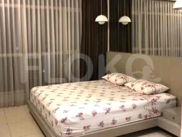 A cozy bedroom featuring a double bed with floral bedding and sheer curtains.