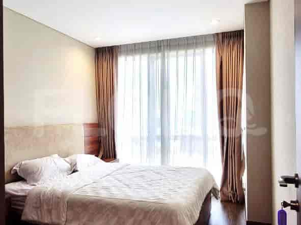Bedroom with a bed, curtains, and large windows.