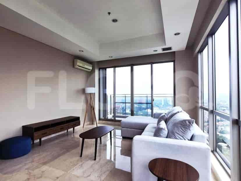 A bright living room with an L-shaped sofa, coffee table, and large windows.
