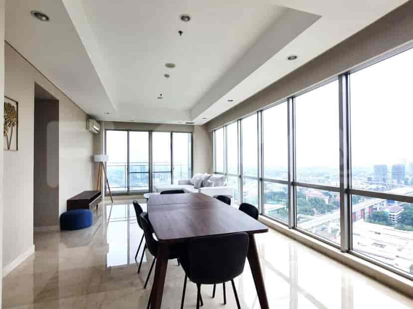 The living room and dining area with a dining table, chairs, and large windows with a city view.
