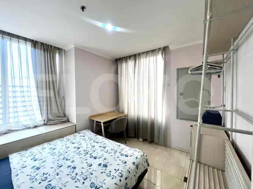 Kamar tidur dengan tempat tidur, meja, dan gorden tipis.