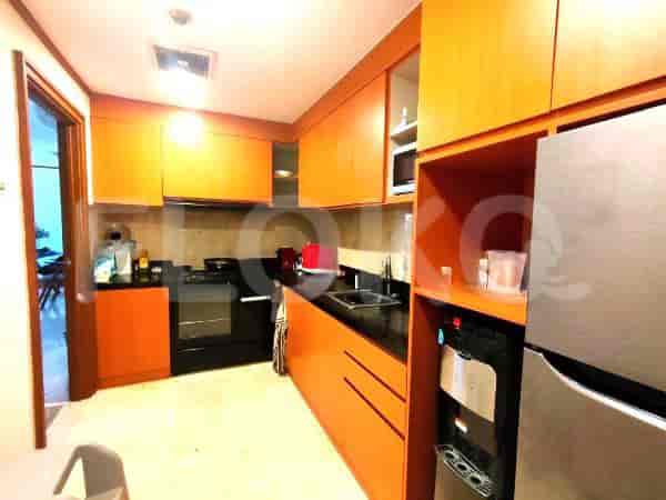 A modern kitchen with wooden cabinets, a stove, and a refrigerator.