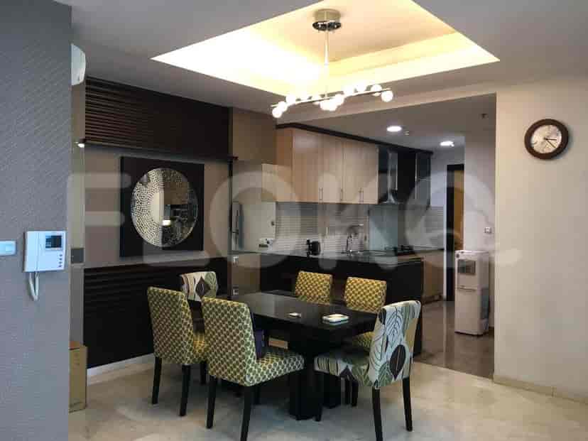 A dining area with a black dining table and chairs, connected to an open kitchen.