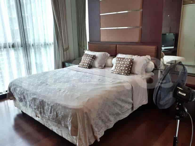 A modern bedroom featuring a king-sized bed with neutral linens.