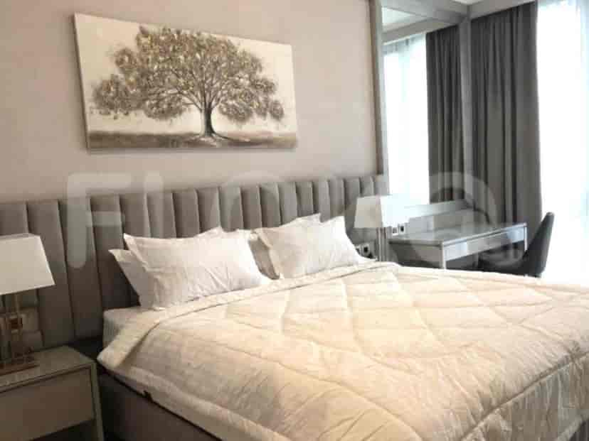 Kamar tidur yang menampilkan tempat tidur, meja samping tempat tidur, dan karya seni.