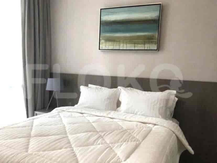 Kamar tidur dengan tempat tidur dan karya seni berbingkai.