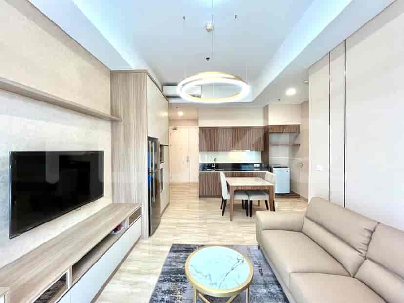 Ruang tamu modern dengan sofa, TV, dan area dapur.