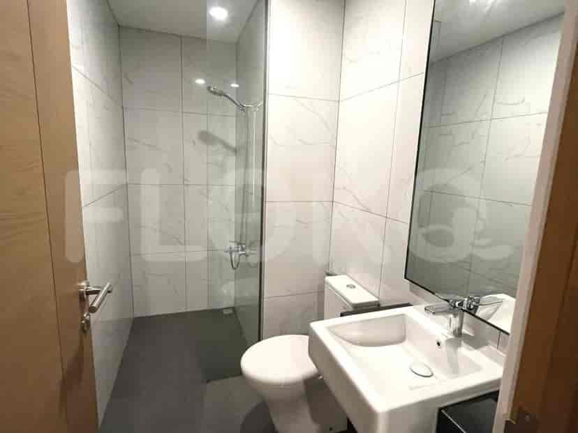 A modern bathroom featuring a walk-in shower, toilet, and sink with a mirror.