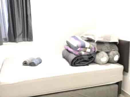 A bedroom featuring a double bed with bedding and pillows.
