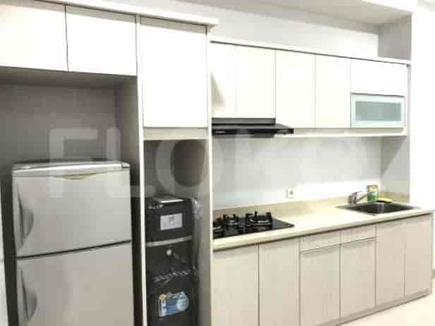 A modern kitchen with light-colored cabinets, a refrigerator and a gas stove.